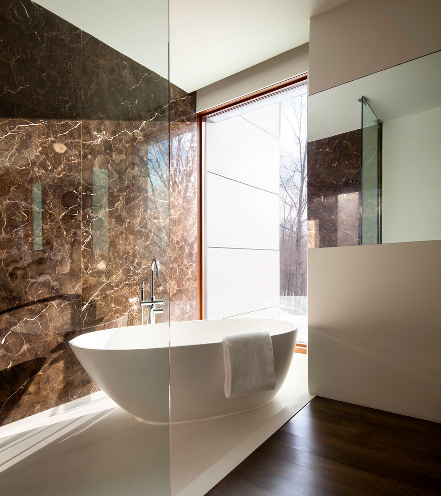 Inspiration for a modern bathroom in New York with a freestanding tub, brown walls, brown tile and stone slab.