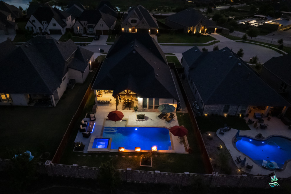 Immagine di una grande piscina naturale minimalista personalizzata dietro casa con una vasca idromassaggio e lastre di cemento