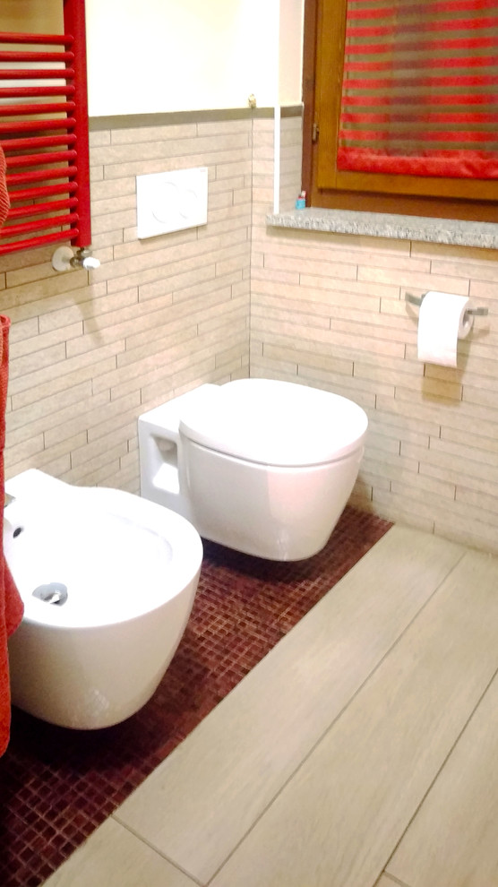 Photo of a mid-sized eclectic master bathroom in Other with flat-panel cabinets, red cabinets, a corner tub, a wall-mount toilet, beige tile, matchstick tile, white walls, porcelain floors, a vessel sink, solid surface benchtops, beige floor and red benchtops.