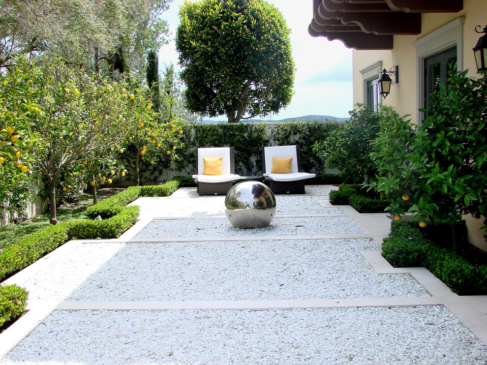 This is an example of a mid-sized contemporary backyard formal garden in Los Angeles with gravel.