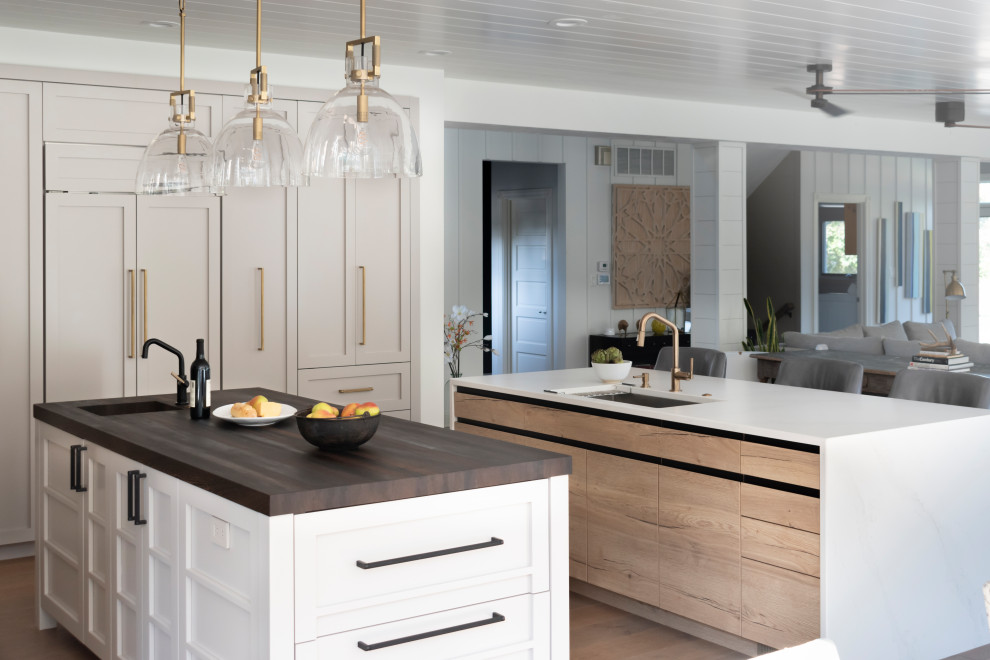 Open concept kitchen - mid-sized rustic l-shaped light wood floor, beige floor and wood ceiling open concept kitchen idea in Chicago with an undermount sink, glass-front cabinets, white cabinets, stainless steel countertops, brown backsplash, ceramic backsplash, colored appliances and two islands