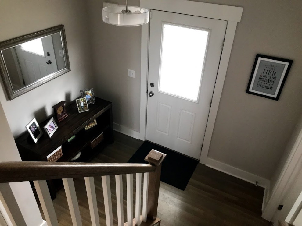 Small arts and crafts foyer in New York with grey walls, painted wood floors, a pivot front door, a white front door and brown floor.