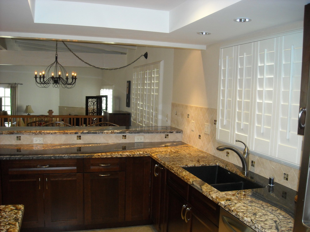 Photo of a modern u-shaped eat-in kitchen in Phoenix with shaker cabinets, dark wood cabinets, granite benchtops, beige splashback and stainless steel appliances.