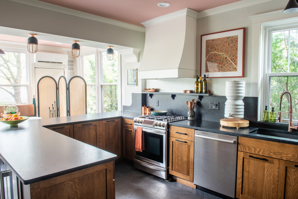 This is an example of a mid-sized eclectic eat-in kitchen in St Louis with an undermount sink, medium wood cabinets, granite benchtops, grey splashback, granite splashback, stainless steel appliances, ceramic floors, grey floor, grey benchtop and shaker cabinets.