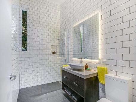 Design ideas for a small contemporary kids bathroom in Melbourne with dark wood cabinets, an open shower, white tile, subway tile, white walls, ceramic floors, a vessel sink and engineered quartz benchtops.
