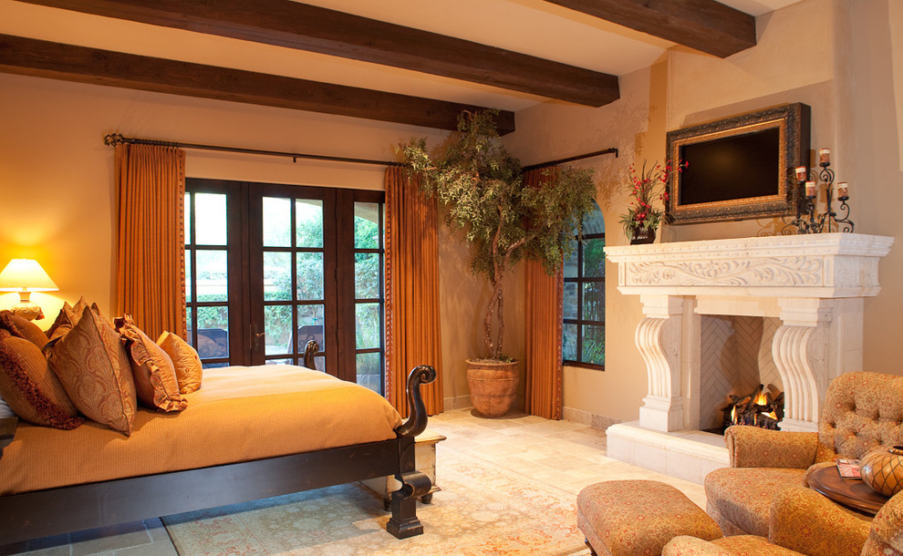 This is an example of an expansive traditional master bedroom in Phoenix with brown walls, terra-cotta floors, a two-sided fireplace and a stone fireplace surround.