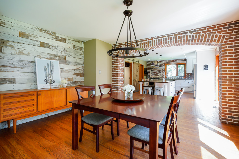 Mid-sized industrial dining room in Other with green walls, medium hardwood floors and brown floor.