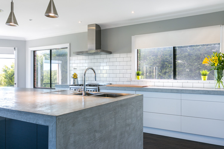 Photo of an expansive contemporary galley eat-in kitchen in Melbourne with a double-bowl sink, open cabinets, white cabinets, concrete benchtops, white splashback, subway tile splashback, stainless steel appliances and with island.