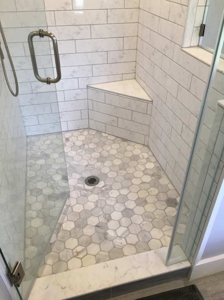 Photo of a mid-sized country master bathroom in Atlanta with shaker cabinets, yellow cabinets, a corner shower, a two-piece toilet, black and white tile, ceramic tile, grey walls, porcelain floors, an undermount sink, marble benchtops, multi-coloured floor, a hinged shower door, multi-coloured benchtops, a niche, a double vanity, a freestanding vanity and planked wall panelling.