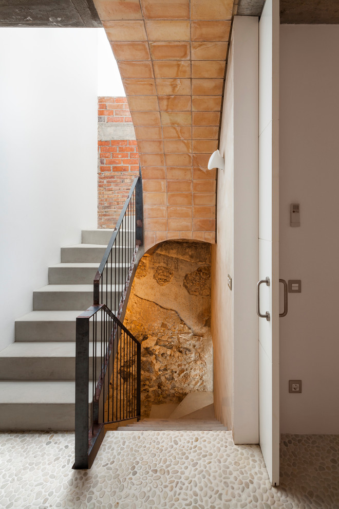 Photo of a mid-sized mediterranean concrete u-shaped staircase in Barcelona with concrete risers.