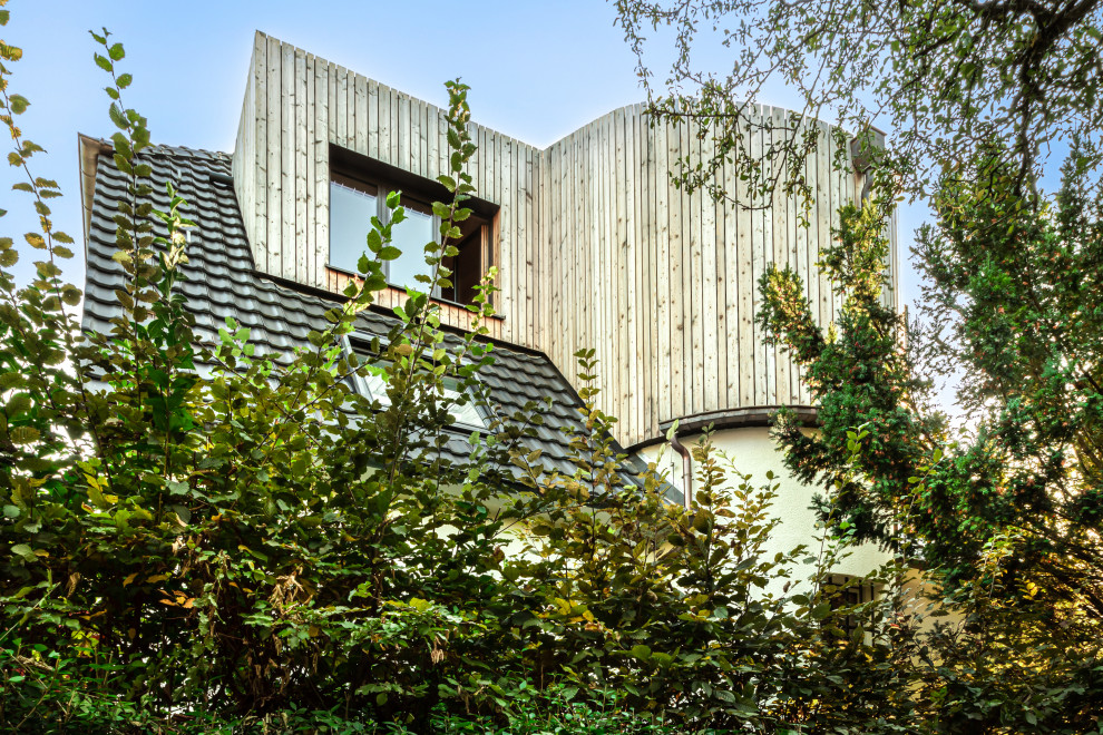 Diseño de fachada de casa escandinava de tamaño medio con revestimiento de madera, tejado a la holandesa y tablilla