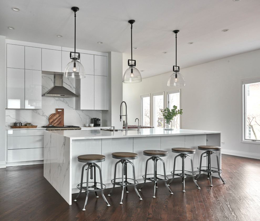 Photo of a large transitional single-wall eat-in kitchen in Chicago with a drop-in sink, flat-panel cabinets, white cabinets, quartzite benchtops, white splashback, marble splashback, stainless steel appliances, dark hardwood floors, with island, brown floor and white benchtop.