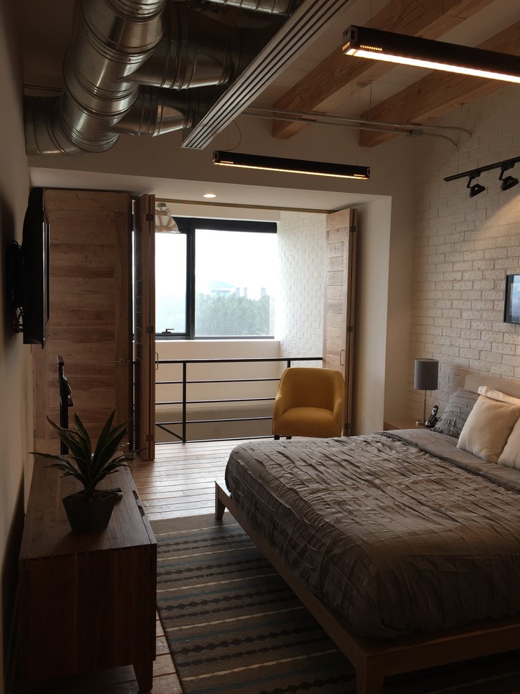Design ideas for a large industrial master bedroom in Mexico City with white walls, medium hardwood floors and brown floor.