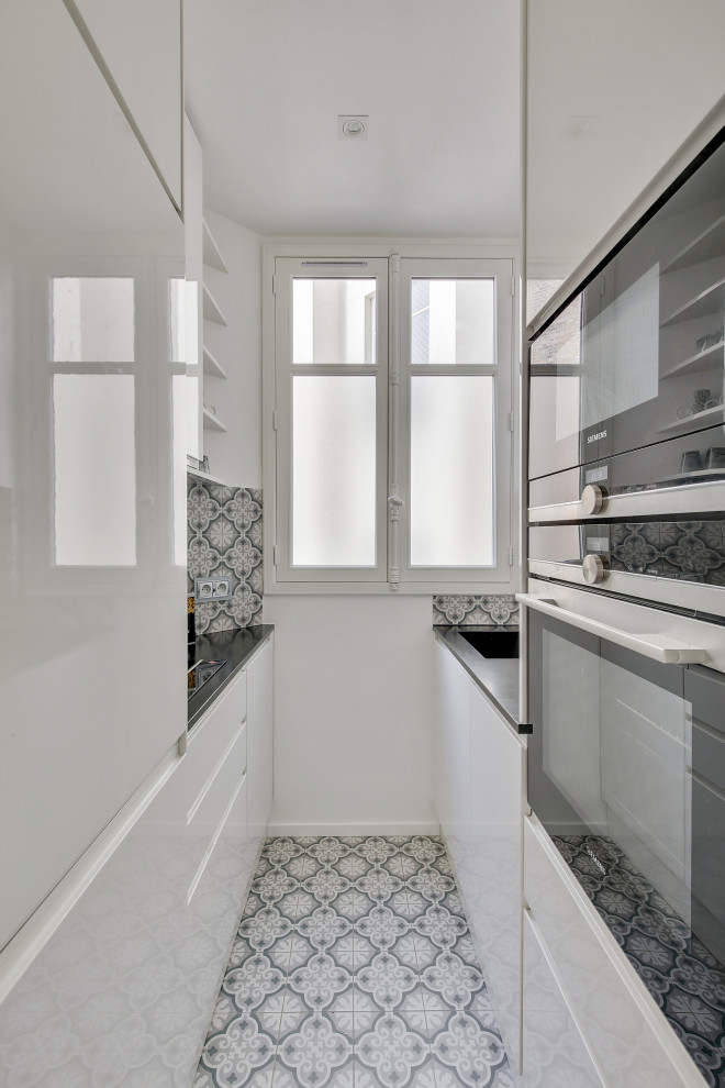 Design ideas for a small traditional galley separate kitchen in Paris with an undermount sink, beaded inset cabinets, granite benchtops, multi-coloured splashback, cement tile splashback, panelled appliances, cement tiles, multiple islands, multi-coloured floor and black benchtop.