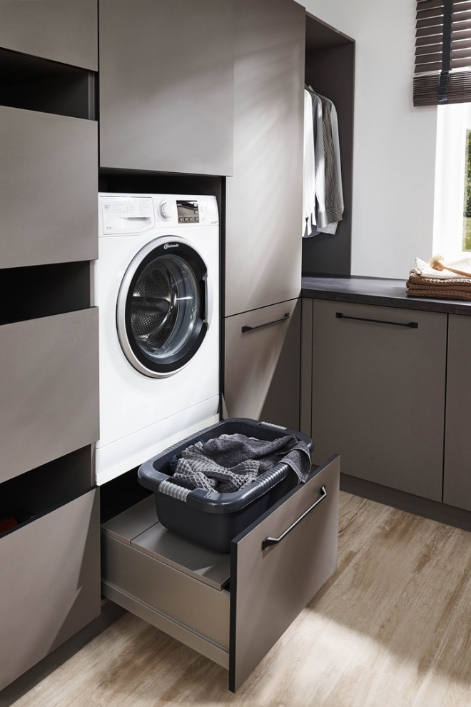 Idéer för att renovera en mellanstor skandinavisk grå l-formad grått liten tvättstuga med garderob, med släta luckor, grå skåp, laminatbänkskiva, vita väggar, laminatgolv och beiget golv