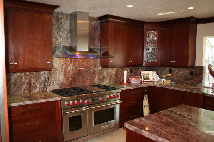 Large transitional u-shaped kitchen photo in Orange County with raised-panel cabinets, dark wood cabinets and stainless steel appliances