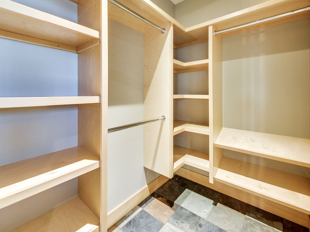 Photo of a mid-sized arts and crafts gender-neutral walk-in wardrobe in Calgary with open cabinets, light wood cabinets and slate floors.