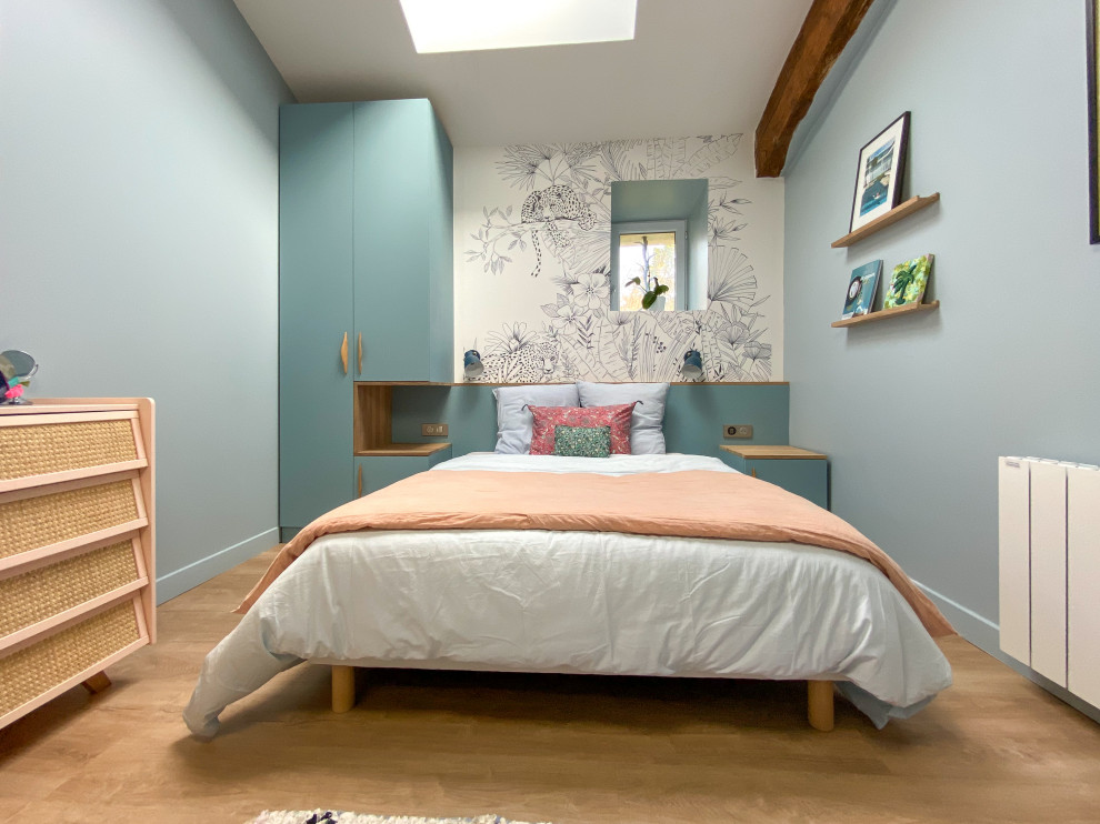 Mittelgroßes Modernes Schlafzimmer ohne Kamin, im Loft-Style mit blauer Wandfarbe, hellem Holzboden und beigem Boden in Bordeaux