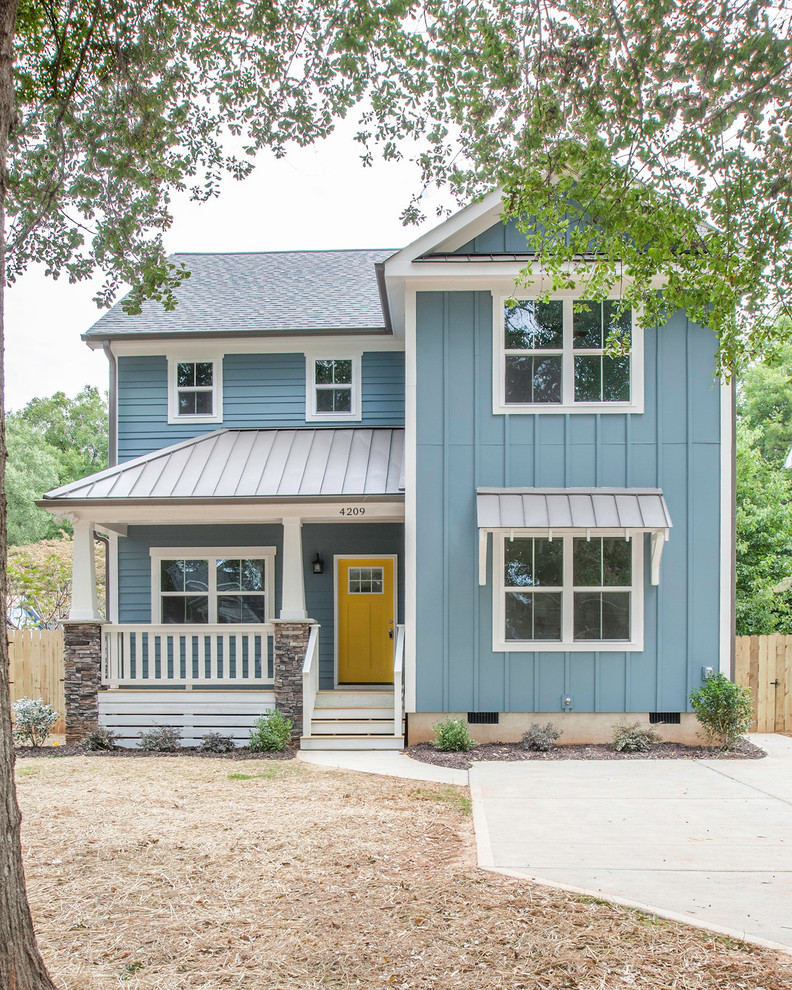 Photo of a beach style two-storey blue house exterior in Charlotte with vinyl siding and a mixed roof.