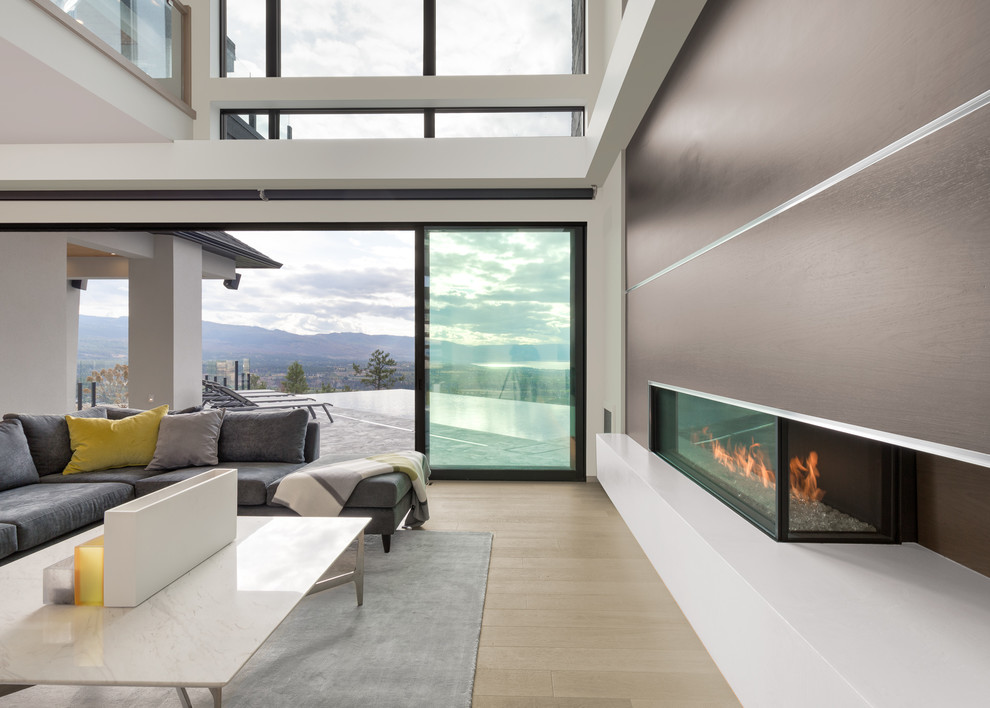 Large open concept living room in Vancouver with a corner fireplace and a wood fireplace surround.