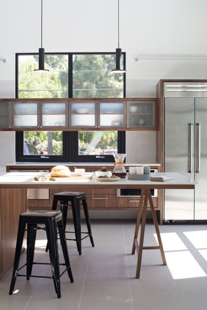 Photo of a mid-sized modern single-wall eat-in kitchen in San Francisco with a single-bowl sink, flat-panel cabinets, medium wood cabinets, quartz benchtops, white splashback, porcelain splashback, stainless steel appliances, porcelain floors and with island.