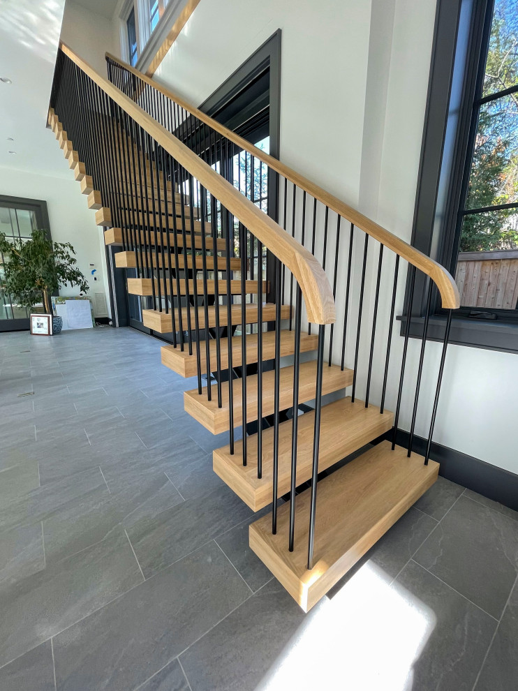 Идея дизайна: огромная лестница на больцах в стиле модернизм с деревянными ступенями, перилами из смешанных материалов и стенами из вагонки