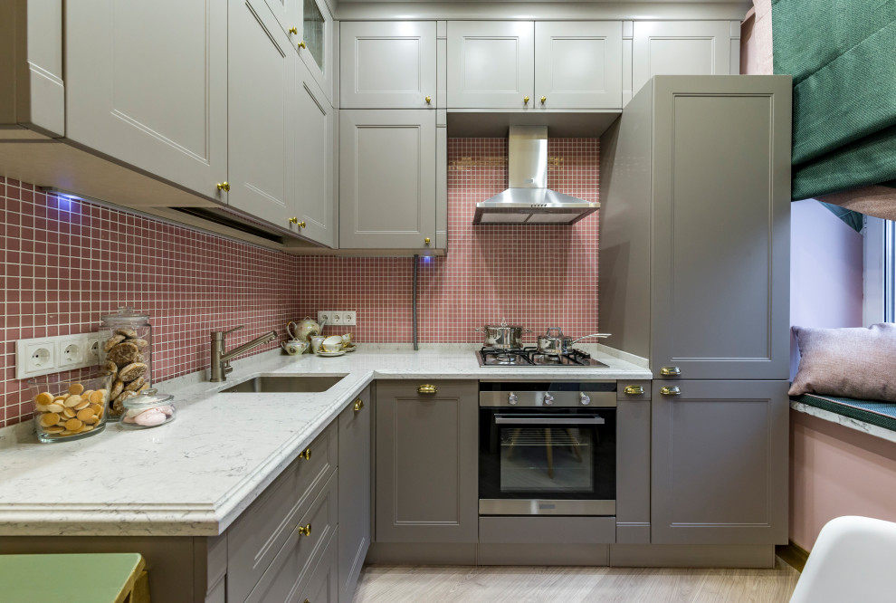 Modelo de cocina actual pequeña con armarios con paneles empotrados, puertas de armario grises, encimera de acrílico, salpicadero con mosaicos de azulejos y encimeras blancas