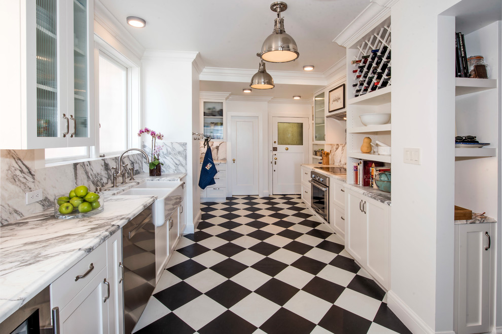 Photo of a mid-sized traditional galley separate kitchen in San Francisco with a farmhouse sink, shaker cabinets, white cabinets, marble benchtops, grey splashback, marble splashback, stainless steel appliances, no island, grey benchtop, vinyl floors and multi-coloured floor.