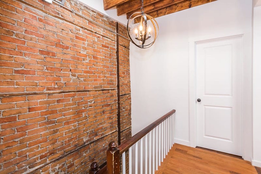 Mid-sized industrial hallway in Boston with white walls and medium hardwood floors.