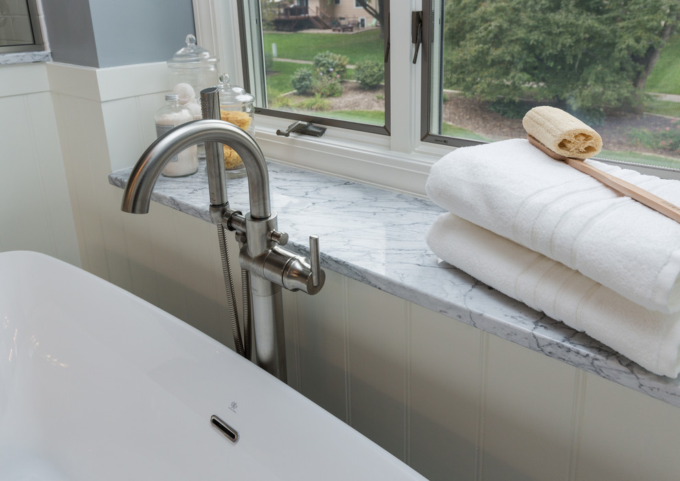 Freestanding bathtub - mid-sized transitional master ceramic tile freestanding bathtub idea with an undermount sink, furniture-like cabinets, white cabinets, marble countertops, a two-piece toilet and gray walls