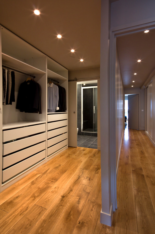 Ejemplo de armario y vestidor contemporáneo pequeño con suelo de madera clara y suelo beige