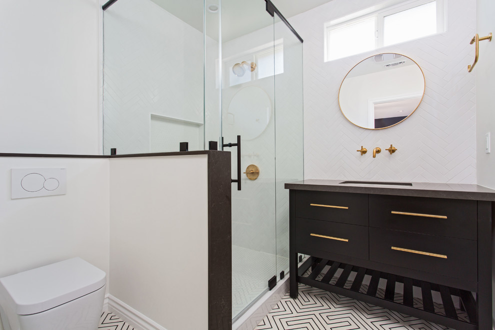 This is an example of a mid-sized scandinavian master bathroom in Los Angeles with flat-panel cabinets, black cabinets, a corner shower, a wall-mount toilet, white tile, subway tile, white walls, cement tiles, an undermount sink, engineered quartz benchtops and a hinged shower door.