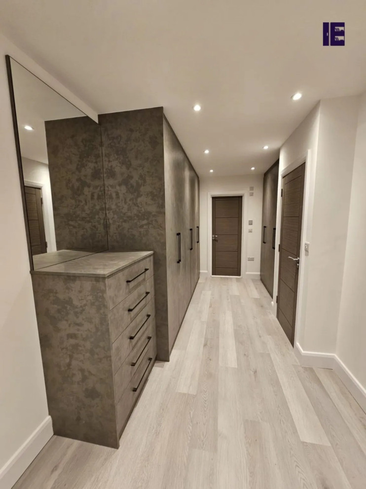 Photo of a large modern standard wardrobe in London with flat-panel cabinets, grey cabinets and feature lighting.