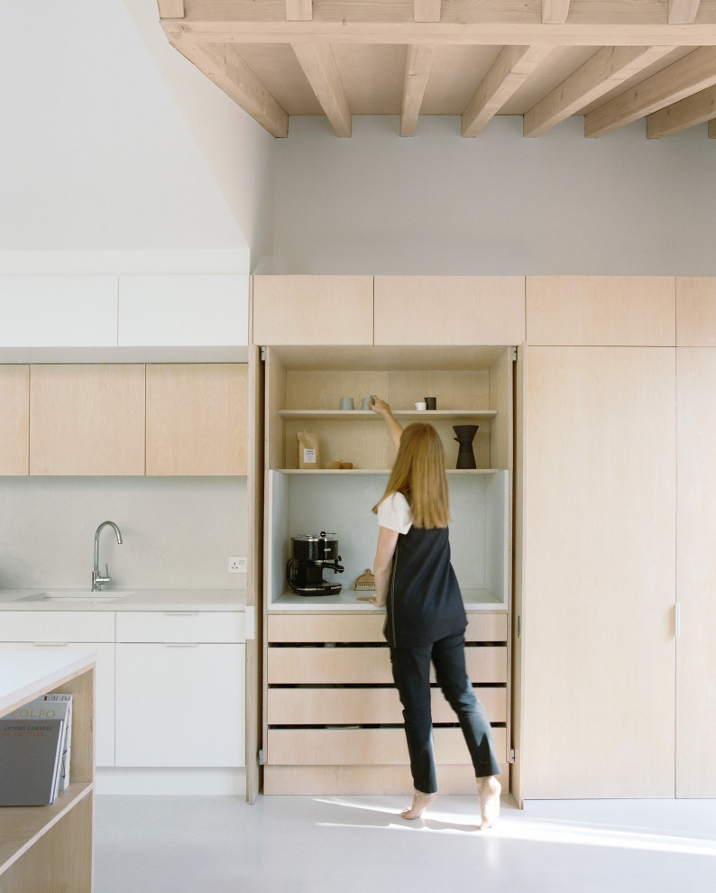 Design ideas for a mid-sized contemporary galley eat-in kitchen in London with an undermount sink, flat-panel cabinets, light wood cabinets, terrazzo benchtops, stainless steel appliances, with island and vaulted.
