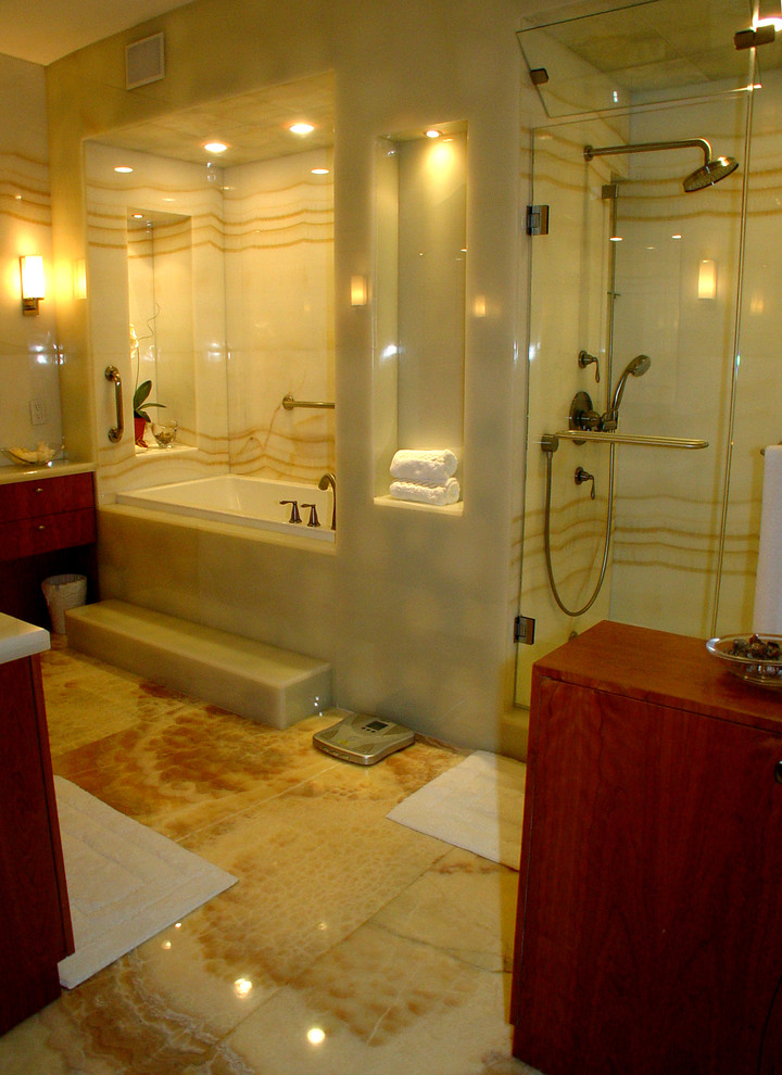 This is an example of a large modern master bathroom in Miami with flat-panel cabinets, light wood cabinets, a corner tub, a corner shower, a two-piece toilet, multi-coloured tile, stone slab, multi-coloured walls, marble floors, a vessel sink, onyx benchtops, multi-coloured floor and a sliding shower screen.