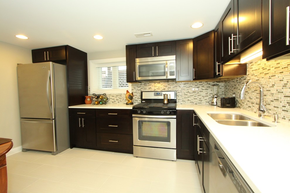 Small transitional l-shaped porcelain tile and gray floor kitchen photo in Chicago with an undermount sink, recessed-panel cabinets, black cabinets, quartz countertops, multicolored backsplash, matchstick tile backsplash, stainless steel appliances, no island and white countertops