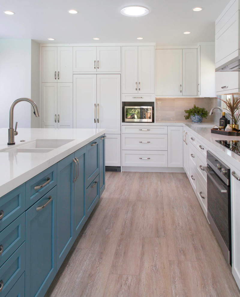 Open concept kitchen - large transitional l-shaped vinyl floor and beige floor open concept kitchen idea in San Diego with an undermount sink, shaker cabinets, white cabinets, quartz countertops, gray backsplash, ceramic backsplash, paneled appliances, an island and white countertops