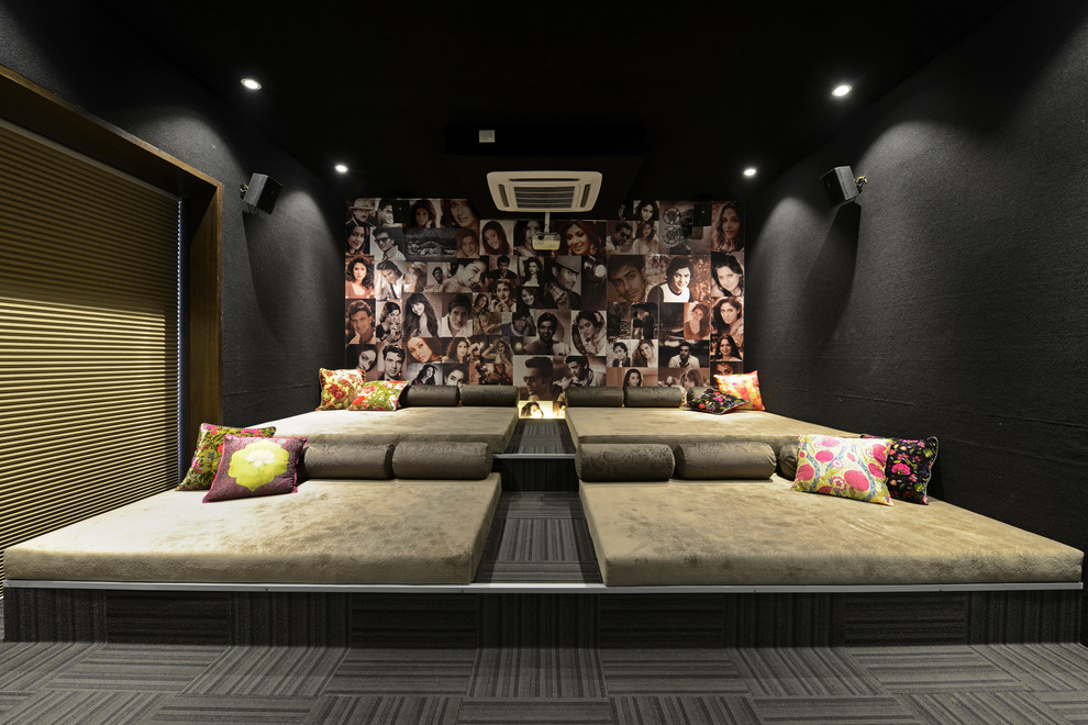 Large contemporary enclosed home theatre in Mumbai with black walls.