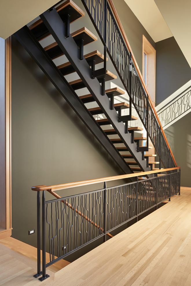 This is an example of a mid-sized modern wood straight staircase in Seattle with open risers.