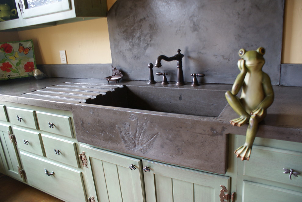 Photo of an eclectic kitchen in Charlotte with an integrated sink, green cabinets and concrete benchtops.