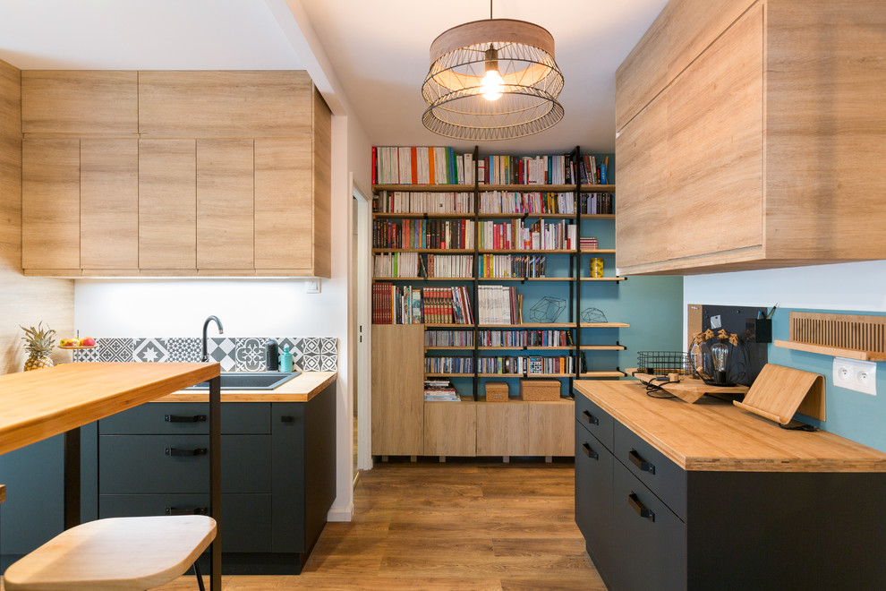 Design ideas for a mid-sized contemporary open plan kitchen in Paris with a drop-in sink, flat-panel cabinets, wood benchtops, ceramic splashback, medium hardwood floors, with island, light wood cabinets and multi-coloured splashback.