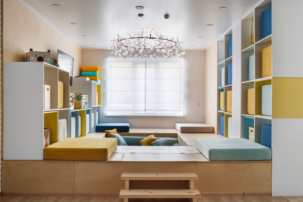 This is an example of a mid-sized contemporary gender-neutral kids' playroom in Other with white walls, light hardwood floors and beige floor.