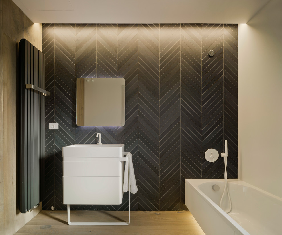 Design ideas for a contemporary master bathroom in Alicante-Costa Blanca with flat-panel cabinets, white cabinets, an alcove tub, a shower/bathtub combo, black tile and white walls.