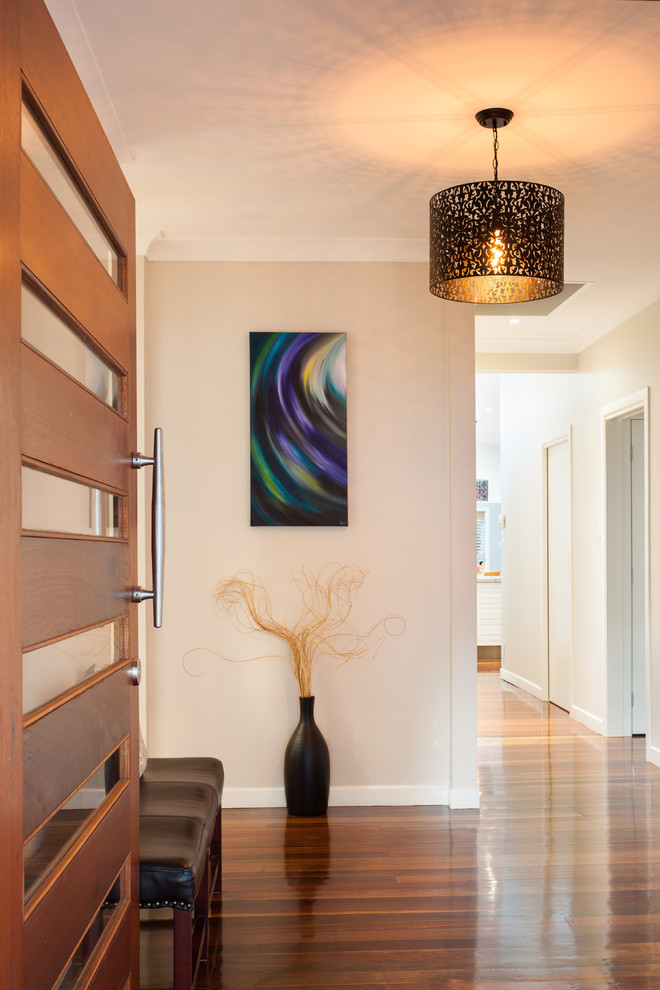 Inspiration for a small transitional medium tone wood floor foyer remodel in Brisbane with white walls and a medium wood front door