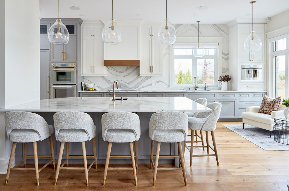 Inspiration for a mid-sized transitional single-wall medium tone wood floor and brown floor eat-in kitchen remodel with an undermount sink, shaker cabinets, blue cabinets, quartz countertops, multicolored backsplash, quartz backsplash, stainless steel appliances, a peninsula and white countertops