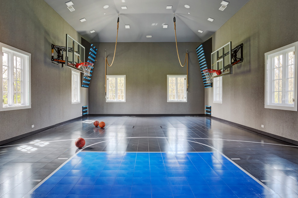 Expansive modern indoor sport court in Chicago with grey walls and blue floor.