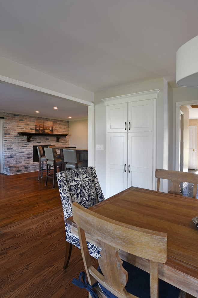 Example of a transitional l-shaped medium tone wood floor eat-in kitchen design in Orange County with a double-bowl sink, shaker cabinets, white cabinets, marble countertops, gray backsplash, glass tile backsplash, stainless steel appliances and an island
