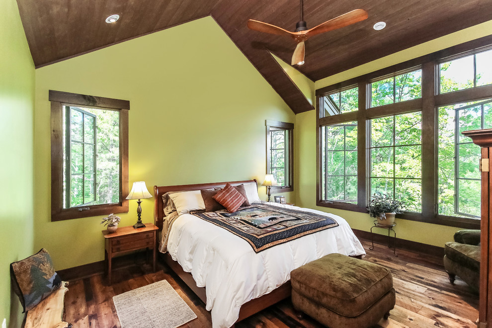 Design ideas for a mid-sized transitional master bedroom in Other with green walls and medium hardwood floors.