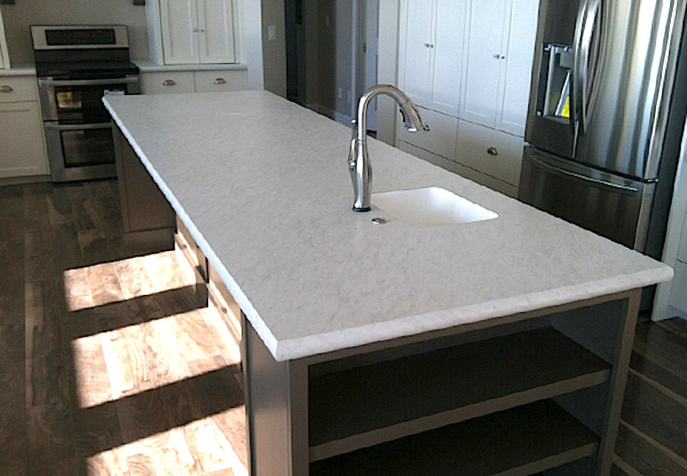 Inspiration for a large transitional l-shaped medium tone wood floor and brown floor kitchen remodel in Boise with an undermount sink, shaker cabinets, white cabinets, quartz countertops, stainless steel appliances, an island and white countertops