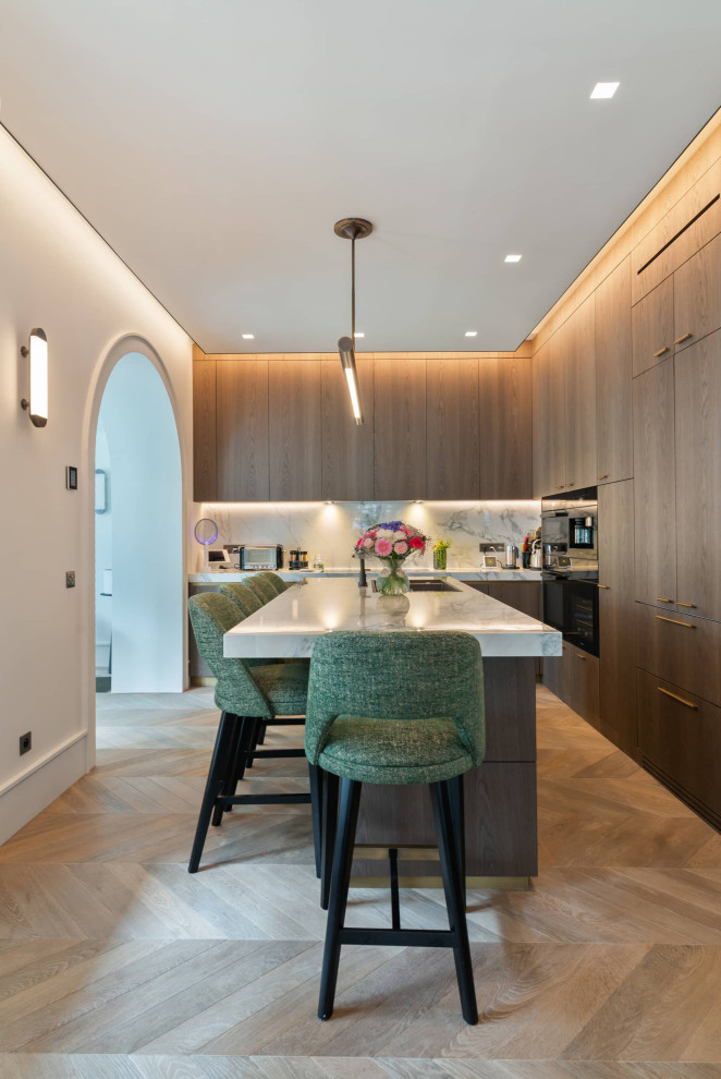 Mittelgroße Moderne Küche in L-Form mit Marmor-Arbeitsplatte, Rückwand aus Marmor, Elektrogeräten mit Frontblende, hellem Holzboden und Kücheninsel in Sonstige